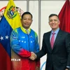 Đại sứ Vũ Trung Mỹ mặc áo đội tuyển Olympic quốc gia Venezuela do Bộ trưởng Franklin Cardillo trao tặng. (Ảnh: ĐSQ cung cấp)