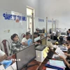 Cán bộ xã Đạo Trù giải quyết thủ tục hành chính cho người dân. (Ảnh: Nguyễn Thảo/TTXVN)
