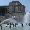 Người dân tránh nóng tại đài phun nước ở Paris, Pháp. (Ảnh: THX/TTXVN)