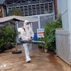 Lực lượng y tế phun độc, khử trùng, dọn dẹp loăng quăng. (Ảnh: TTXVN)