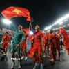 Các cầu thủ U22 Việt Nam hân hoan chia vui với người hâm mộ trên sân Rajamangala. (Ảnh: Minh Quyết/TTXVN)