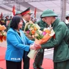 Bí thư Thành ủy Hà Nội Bùi Thị Minh Hoài tặng hoa, động viên và tiễn tân binh Quận Ba Đình lên đường nhập ngũ. (Ảnh: Văn Điệp/TTXVN)