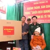 Thiếu tướng Nguyễn Trần Long, Ủy viên Ban Thường vụ Đảng uỷ, Phó Chính ủy Quân đoàn 34, trao tặng quà cho hộ gia đình bà Tô Thị Sửa. (Ảnh: Quang Thái/TTXVN)