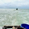 Lai dắt tàu cá gặp nạn vào bờ. (Ảnh minh họa: TTXVN phát)
