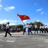 Đi đầu là đội danh dự với Quân kỳ Quyết thắng qua lễ đài trước cờ Tổ quốc và cột mốc chủ quyền đảo Trường Sa. (Ảnh: Huy Khánh/Vietnam+)