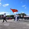 Đi đầu là đội danh dự với Quân kỳ Quyết thắng qua lễ đài trước cờ Tổ quốc và cột mốc chủ quyền đảo Trường Sa. (Ảnh: Huy Khánh/Vietnam+)