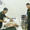 Các bác sỹ quân y tại Bệnh xá đảo Nam Yết thăm khám cho bệnh nhân Đoàn Tính. (Ảnh: TTXVN phát)