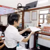 Cán bộ trao trả kết quả thủ tục hành chính cho người dân tại Trung tâm hành chính công xã. (Ảnh: Thái Thuần/TTXVN)