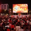 Người hâm mộ ngồi trật tự chuẩn bị xem trận bán kết qua màn hình Led khổng lồ có kích thước 12m x 7m tại phố đi bộ Nguyễn Huệ. (Ảnh: Trung Tuyến/TTXVN)