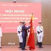 Tổng Bí thư Tô Lâm gắn huy hiệu “Anh hùng lực lượng vũ trang nhân dân” lên lá cờ truyền thống của Cục An ninh mạng và phòng, chống tội phạm sử dụng công nghệ cao, Bộ Công an. (Ảnh: Phạm Kiên/TTXVN)