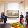 Phu nhân Ngô Phương Ly tặng bức tranh “Những đồi cọ” của cố họa sỹ Phan Kế An. (Ảnh: Tâm Hằng/TTXVN)