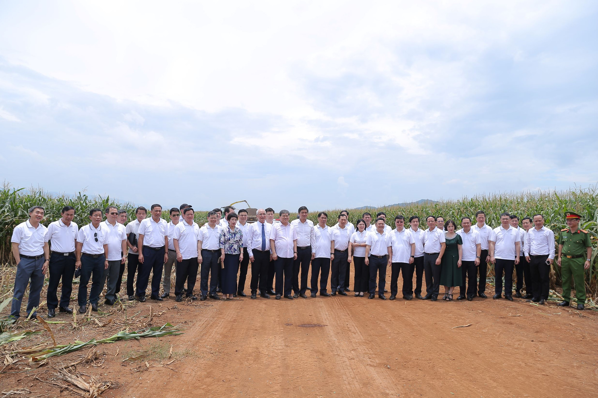 Các đại biểu cùng thành viên lớp bồi dưỡng cán bộ quy hoạch Ủy viên Ban Chấp hành Trung ương Đảng khóa XIV, chụp ảnh tại cánh đồng ứng dụng công nghệ cao TH. (Ảnh: HV/Vietnam+) vnp_TH 3.jpg