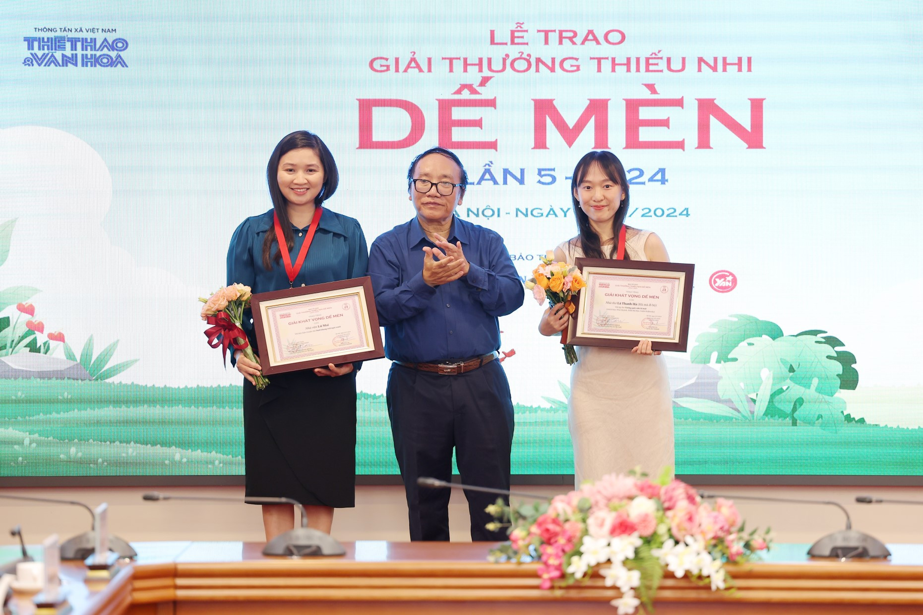 Nhà thơ Trần Đăng Khoa, Phó Chủ tịch Hội Nhà văn Việt Nam, Chủ tịch Hội đồng Giám khảo trao giải Khát vọng Dế mèn cho nhà thơ Lữ Mai (trái) và nhà thơ Lê Thanh Hà (phải). (Ảnh: PV/Vietnam+) demen.jpg
