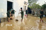 Cán bộ chiến sỹ Trung đoàn 95 giúp người dân dọn dẹp khắc phục hậu quả lũ lụt. (Ảnh: Danh Lam/TTXVN)
