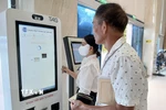 Hướng dẫn người dân đăng ký khám, chữa bệnh và thanh toán viện phí qua căn cước công dân gắn chíp. (Ảnh: Mỹ Hà/TTXVN)