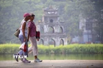 Du khách nước ngoài đi dạo bên hồ Hoàn Kiếm. (Ảnh: Tuấn Đức/TTXVN)