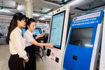 Nhân viên y tế hướng dẫn người dân tại máy đăng ký khám bệnh tự động ở Bệnh viện Đa khoa tỉnh Quảng Ninh. (Ảnh: T.G/Vietnam+)