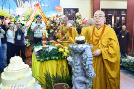 Các đại biểu và Phật tử thực hiện nghi thức tắm Phật tại Đại lễ Phật đản. (Ảnh: Minh Đức/TTXVN)