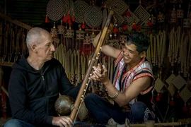 Du khách quốc tế học cách chơi nhạc cụ Tây Nguyên với người dân bản địa. (Nguồn ảnh: Cục Du lịch Quốc gia Việt Nam)