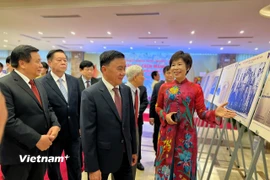 Tổng Giám đốc Thông tấn xã Việt Nam giới thiệu những hình ảnh quý trong triển lãm. (Ảnh: Mai Mai/Vietnam+)