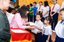 Chủ tịch Miss World, bà Julia Morley trao quà cho trẻ em và phụ nữ khó khăn Việt Nam. (Ảnh: CTV/Vietnam+)