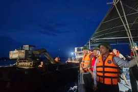 Ông Phạm Đức Ấn (ngoài cùng bên phải), Phó Bí thư Tỉnh ủy, Chủ tịch UBND tỉnh Quảng Ninh cùng lãnh đạo tỉnh, các sở, ban, ngành liên quan có mặt trực tiếp tại hiện trường để chỉ đạo công tác cứu hộ. (Ảnh: Thanh Vân/TTXVN)