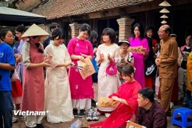 Nhóm du khách Hàn Quốc trải nghiệm với di sản Tranh Đông Hồ của Việt Nam. (Ảnh: Xuân Mai/Vietnam+)