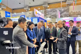 Đại biểu và khách tham quan trải nghiệm gian hàng công nghệ số trong lĩnh vực dịch vụ du lịch tại hội chợ. (Ảnh: Mai Mai/Vietnam+)