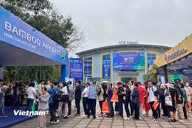 Khách tham quan xếp hàng tham gia các chương trình vui chơi có thưởng và mua vé máy bay ưu đãi ngay sau khai mạc hội chợ sáng nay, ngày 10/4. (Ảnh: Mai Mai/Vietnam+)