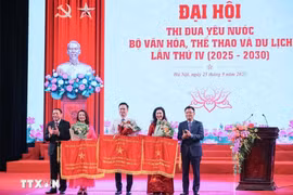 Phó Thủ tướng Lê Thành Long và Bộ trưởng Bộ Văn hóa, Thể thao và Du lịch Nguyễn Văn Hùng trao cờ thi đua của Chính phủ cho các đơn vị đạt thành tích xuất sắc. (Ảnh: Hoàng Hiếu/TTXVN)