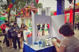 Du khách trải nghiệm vẽ chân dung miễn phí tại sự kiện. (Ảnh: Mai Mai/Vietnam+)