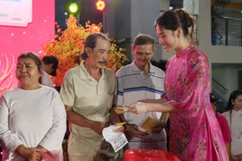 Hoa hậu Lương Thùy Linh trao quà cho các hộ gia đình khó khăn. (Ảnh: CTV/Vietnam+)