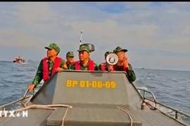 Cán bộ, chiến sỹ đồn Biên phòng tại Cô Tô kêu gọi tàu thuyền vào nơi tránh trú bão số 9. (Ảnh: TTXVN phát)