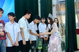 Hoa hậu Hà Linh trao những phần quà đặc biệt cho các em học sinh học giỏi có hoàn cảnh khó khăn. (Ảnh: CTV/Vietnam+)