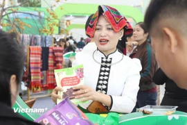 Hoàng Thị Bích với bộ trang phục truyền thống của người Thái trắng ở Mộc Châu, giới thiệu sản phẩm tại tại Hội chợ mùa Thu 2025. (Ảnh: Phi Tuấn/Vietnam+)