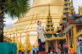 Thanh Thủy diện trang phục truyền thống Myanmar trong chuyến thăm Shwedagon Pagoda. (Ảnh: CTV/Vietnam+)