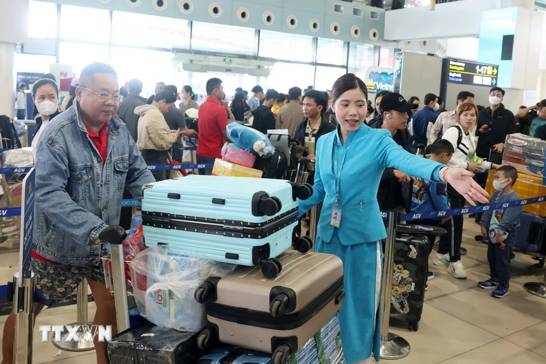 Mặc dù đông nhưng người dân, hành khách vẫn nhận được sự phục vụ, hướng dẫn nhiệt tình từ nhân viên mặt đất. (Ảnh: Quốc Khánh/TTXVN)