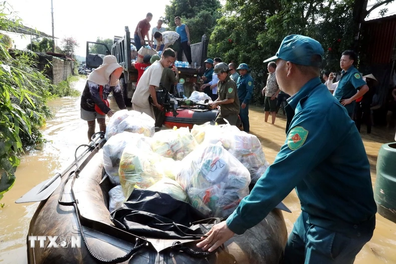 Vận chuyển hàng hóa bằng thuyền đến các thôn bị ngập sâu ở xã Vân Nham, tỉnh Lạng Sơn. (Ảnh: Văn Đạt/TTXVN)