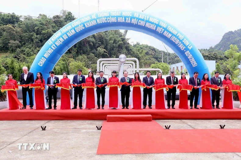 Đại biểu thực hiện nghi lễ cắt băng khánh thành công trình: Hệ thống thoát nước và xử lý nước thải thành phố Sơn La. (Ảnh: Quang Quyết/TTXVN)