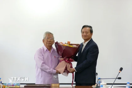 Đại sứ Việt Nam tại Lào Nguyễn Minh Tâm tặng hoa chúc mừng Nghệ sỹ Quốc gia-nhạc sỹ Lào Douangmixay Likaya. (Ảnh: Xuân Tú/TTXVN)