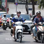 Người dân mặc đồ bảo hộ chống nắng nóng khi tham gia giao thông trên đường Hùng Vương, phường Thuận Hóa, thành phố Huế. (Ảnh: Nguyên Lý/TTXVN)