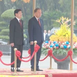 Tổng Bí thư Tô Lâm và Tổng Bí thư, Chủ tịch nước Lào Thongloun Sisoulith trên bục danh dự, thực hiện nghi thức chào cờ. (Ảnh: Thống Nhất/TTXVN)
