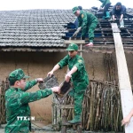Lực lượng Đồn Biên phòng Tùng Vài (Tuyên Quang) giúp người dân lợp lại mái nhà cho người dân bị ảnh hưởng của mưa đá, dông lốc. (Ảnh: Đức Thọ/TTXVN)