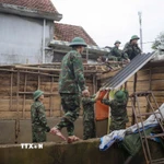 Lực lượng bộ đội ra quân giúp dân xây dựng và sửa chữa nhà cửa bị ảnh hưởng bởi mưa lũ tại xã Lộc An, thành phố Huế. (Ảnh: Mai Trang/TTXVN)