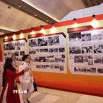 Đại biểu xem Trưng bày ảnh “Dưới cờ Đảng - Đất nước tiến vào Kỷ nguyên mới” do Thông tấn xã Việt Nam thực hiện. (Nguồn: TTXVN)