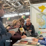 Du khách tìm hiểu các chương trình tham quan Việt Nam tại Triển lãm du lịch thế giới, được tổ chức từ ngày 12-15/3 tại thủ đô Paris. (Ảnh: Hữu Chiến/TTXVN)