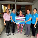 Chị Đặng Thị Huê, vượt khó nuôi con học đại học, nhận vốn cho vay của Hội Liên hiệp Phụ nữ xã Long Cang, tỉnh Tây Ninh. (Ảnh: Đức Hạnh/TTXVN)