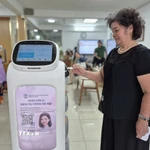Người dân trải nghiệm Robot AI áp dụng công nghệ trí tuệ nhân tạo hỗ trợ thực hiện các thủ tục hành chính ở phường Cửa Nam. (Ảnh: Nguyễn Thắng/TTXVN)
