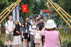 Các gia đình lưu lại khoảnh khắc tại Làng Văn hóa Du lịch các Dân tộc Việt Nam. (Ảnh: Khánh Hòa/TTXVN)