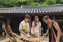 Du khách Hàn Quốc trực tiếp trải nghiệm đàn T'Rưng, nhạc cụ dân tộc của vùng đất Tây Nguyên, Việt Nam. (Nguồn ảnh: Tarzan Tây Nguyên)